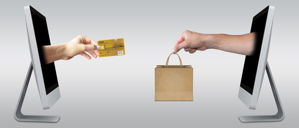 computer holding credit card and computer holding shopping bag
